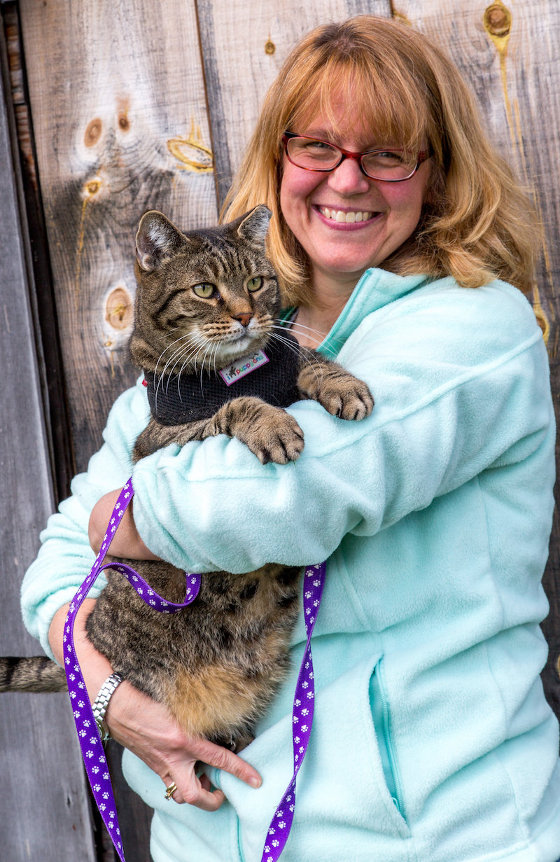 Woman holding cat and smiling